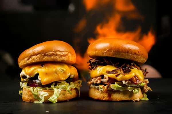 two burgers with dark fiery background