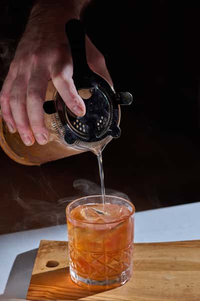 partender straining a drink