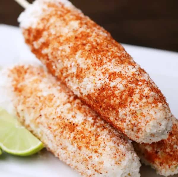 Classic Mexican street corn on the cob coated in creamy mayo, crumbled cotija cheese, and chili powder—served with lime wedges for a zesty, flavorful elote experience.