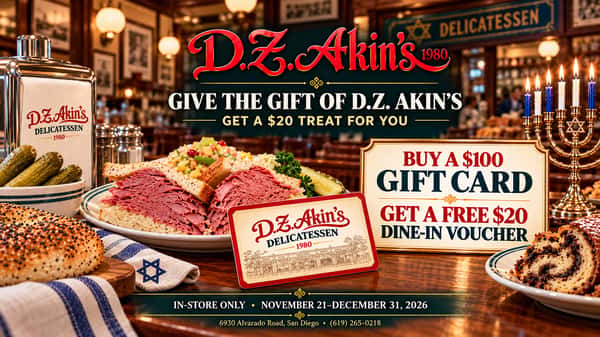 D.Z. Akin's holiday gift card advertisement set inside the restaurant, featuring a menorah, traditional deli foods and a D.Z. Akin's gift card. Buy a $100 gift card and receive a free $20 dine-in voucher, in-store November 21–December 31, 2026.
