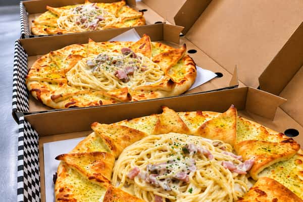 Freshly baked pizzas topped with cheese, onions and herbs in takeaway boxes from Ciao Bella in Westhill