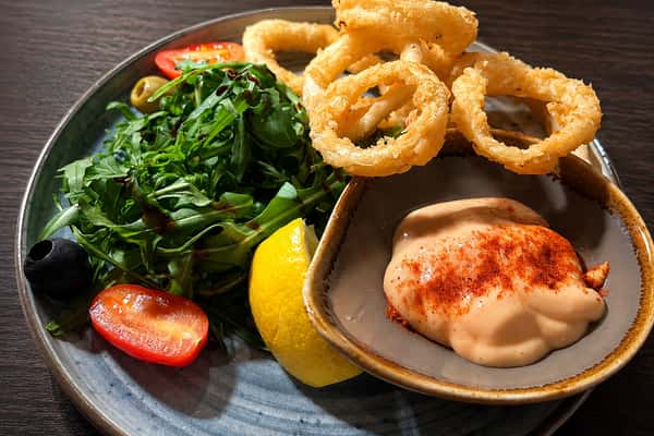 Crispy calamari with fresh greens, lemon and creamy dipping sauce from Ciao Bella