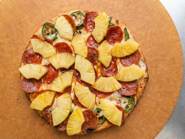 Hand-tossed pizza topped with pepperoni, pineapple, fresh jalapeños, melted mozzarella, and a golden baked crust.