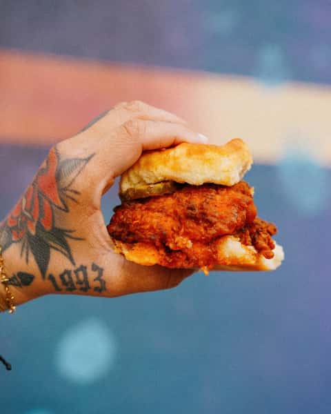 Hand holding a chicken biscuit sandwich