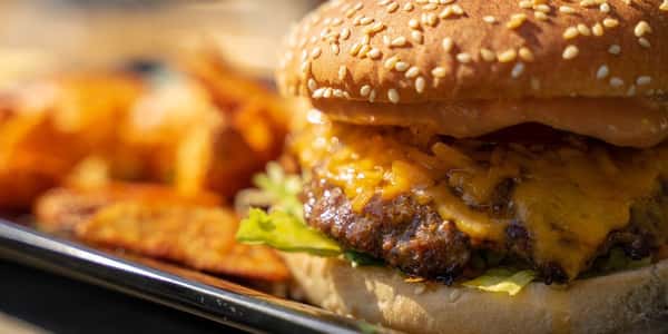 Cheesy burger served with seasoned fries