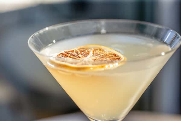 Martini garnished with a dried citrus wheel in a martini glass at a restaurant