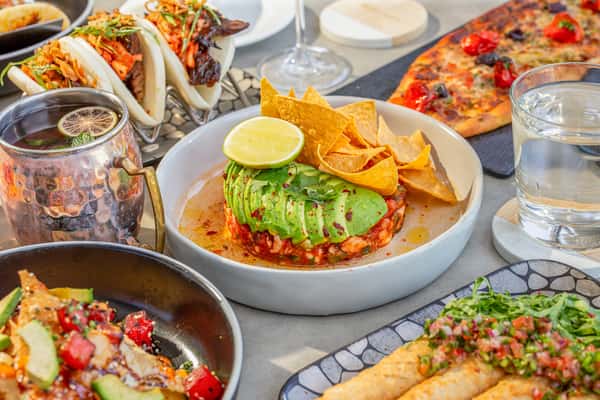Whiskey Charlie dining spread with tacos, avocado dip, chips and cocktails at The Wharf in Washington, DC
