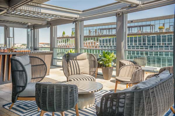 Outdoor lounge seating on the Whiskey Charlie rooftop deck overlooking The Wharf in Washington, DC