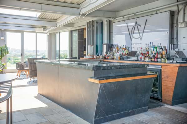 Covered rooftop deck with modern lounge seating at Whiskey Charlie at The Wharf in Washington, DC