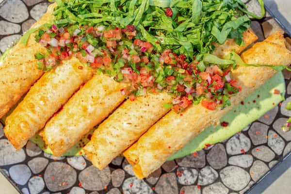 Crispy chicken taquitos topped with fresh salsa and greens at Whiskey Charlie in Washington, DC