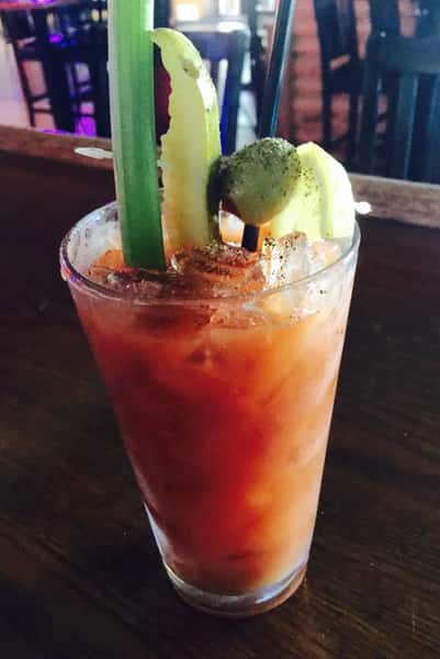 Bloody Mary with celery stick, pickle, olive and lemon sticking out