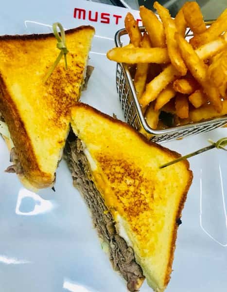 Italian beef piled up with sauteed green peppers and onions with melted Swiss and American cheeses served on grilled Texas toast with a side of fries