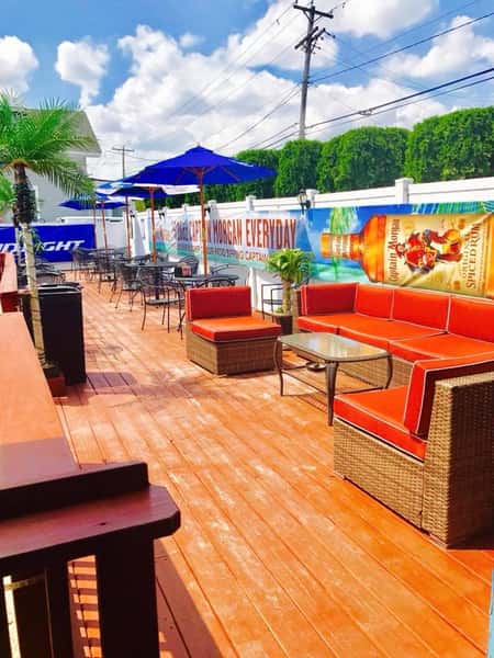 Outside deck with lounge area and dining tables with umbrellas