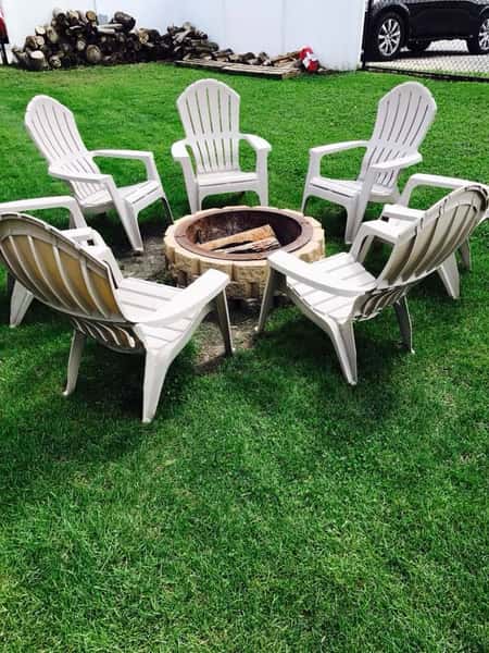Outside seating area with lawn chairs set around a fire pit