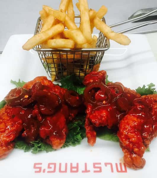 Boneless wings covered in Teriyaki sauce with a side of fries