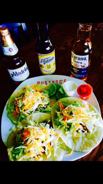 Soft Tacos stuffed with veggies and topped with mexican cheese with a side of lime, sour cream, and salsa