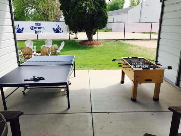 Outside area with foosball and ping pong table with fire pit in the background