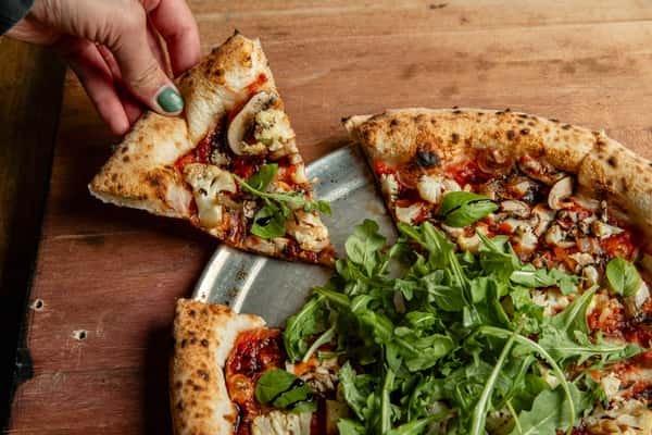 Hand grabbing a slice of pizza