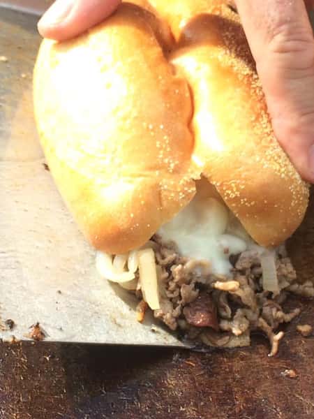 cheesesteak face down on a grill