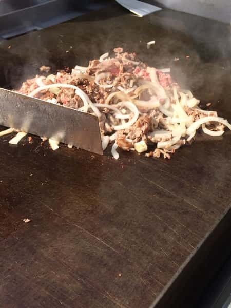 grilled meat topped with cheese topped with onions