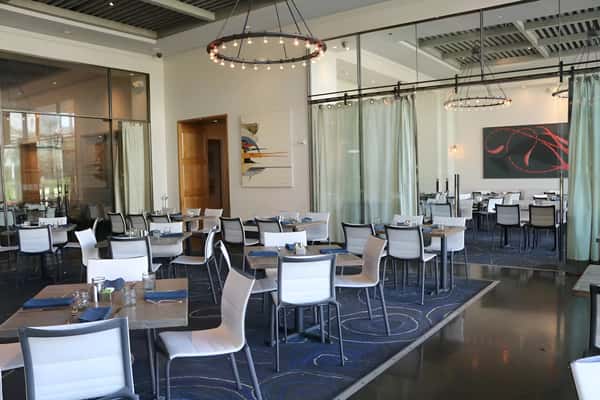 Contemporary dining room with comfortable seating and floor to ceiling windows.