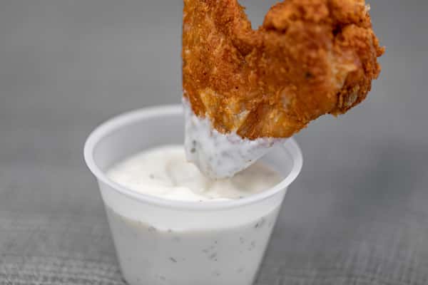 Wing being dipped into sauce
