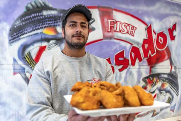 Person holding a plate of chicken wings