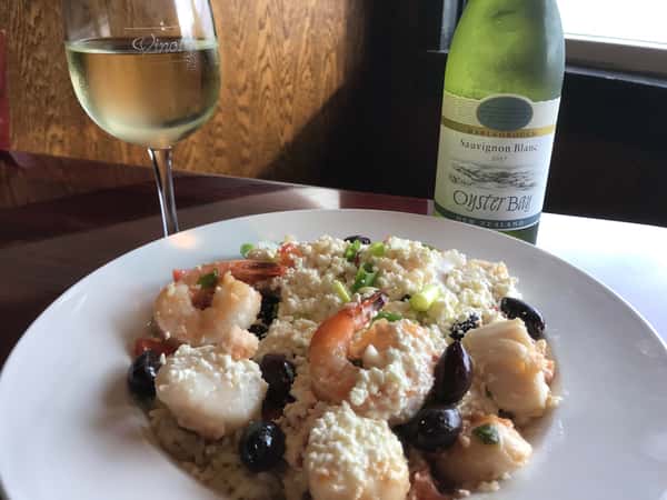 Shrimp dinner with a glass of wine and wine bottle