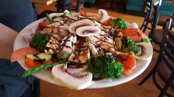 plate of chicken, fresh mozzarella, mushroom, red onion, tomato, broccoli and asparagus topped with balsamic drizzle