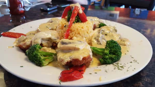 breaded chicken with roasted peppers, broccoli and mushrooms in a white cream sauce served with a side of rice