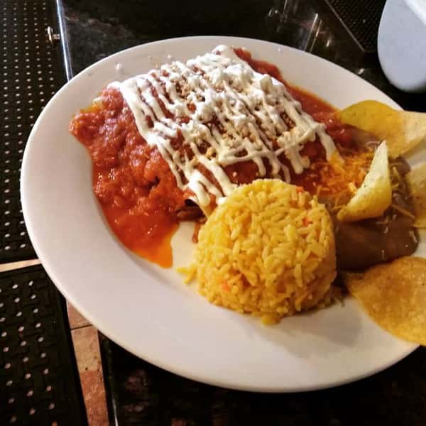 enchiladas with refried beans and rice with a side of tortilla chips