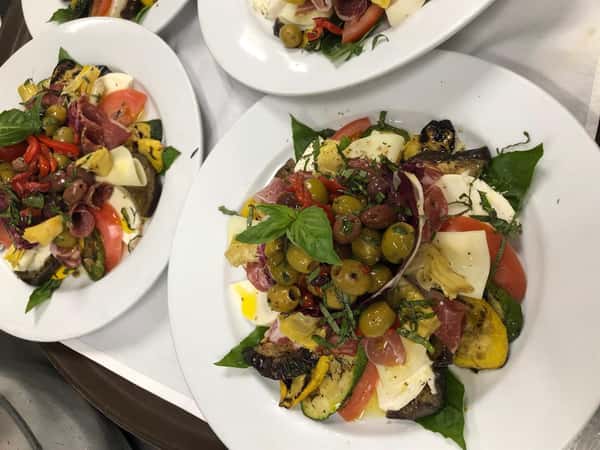 An assortment of Antipasto Salads on dishes in the kitchen