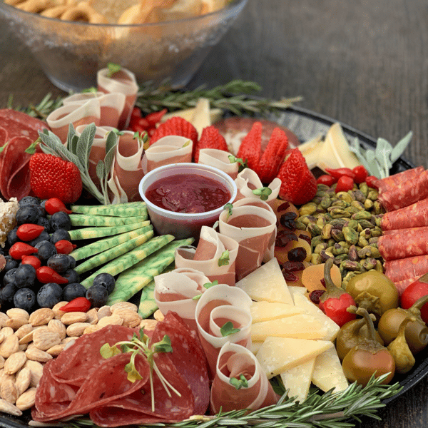 Beautifully arranged charcuterie board featuring cured meats, artisan cheeses, fresh fruit, nuts