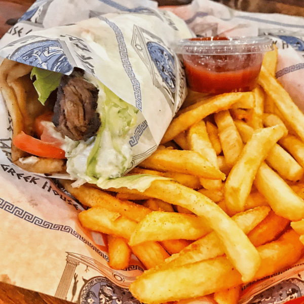 Beef gyro wrap with lettuce, tomato, and tzatziki sauce, served with golden fries and a side of ketchup.