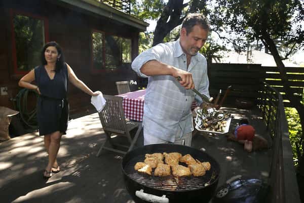 Karen Gioia and Will Gioia cooking out on a grill