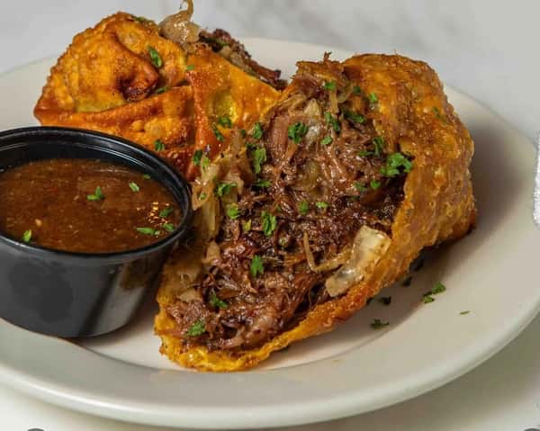 Braised Oxtail and Cabbage wrapped in wonton wrap and served with a side of Bussin Sauce.