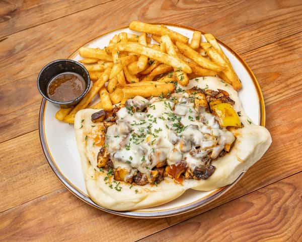 Saucy meat sandwich with fries and sauce