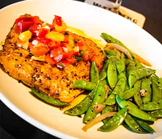 Grilled salmon topped with diced red and yellow peppers, served with sautéed sugar snap peas and onions.