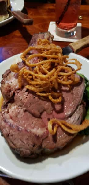 Sliced steak served alongside pasta tossed in a savory red sauce.