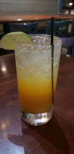 Refreshing orange-colored cocktail served over ice with a straw.