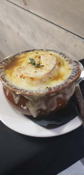 Rich French onion soup topped with melted, golden-brown cheese and served in a crock.