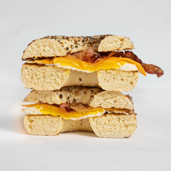 Breakfast bagel sandwich with bacon, fried egg, and melted cheese on a seeded bagel from The Spoke café.