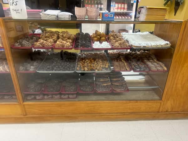 Glass display case filled with assorted donuts at a bakery.