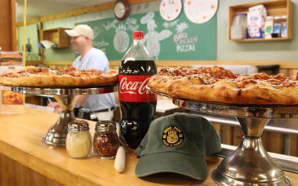 pepperoni pizza on a counter with a bottle of soda