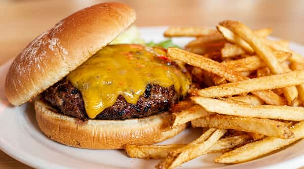 Cheeseburger with melted cheddar and a side of golden-brown french fries.