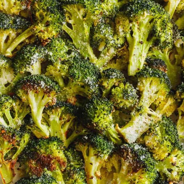 Creamy chicken and broccoli skillet with spinach, topped with red pepper flakes, served on a white plate.