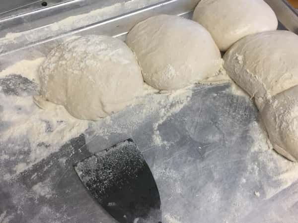 Fresh balls of dough covered in flour