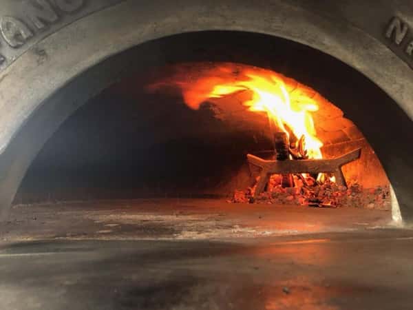 wood fired brick oven with a fire inside