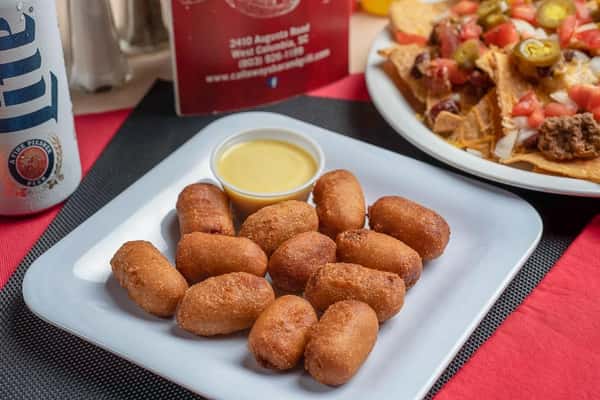 assortment of corn dogs on a plate with a side of honey mustard