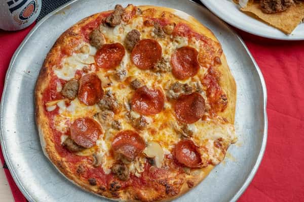 round pizza with sauce, cheese, and topped with pepperoni and meatballs